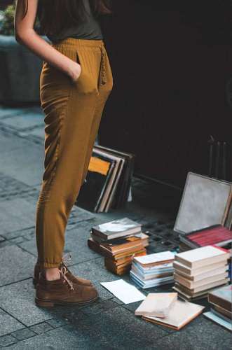 literature woman standing in front of books on the floor