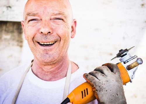 carpenter Close-up of a bald man holding a grinder