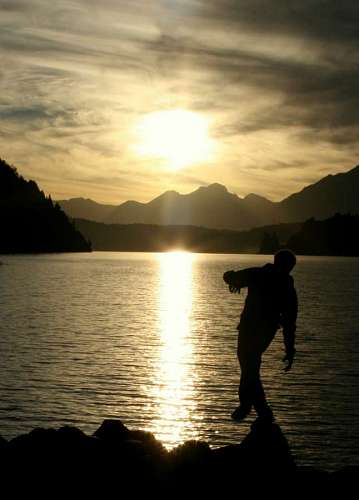 ocaso Man doing balance on rocks with lake in background