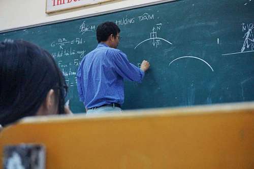 asian teacher writing on the blackboard