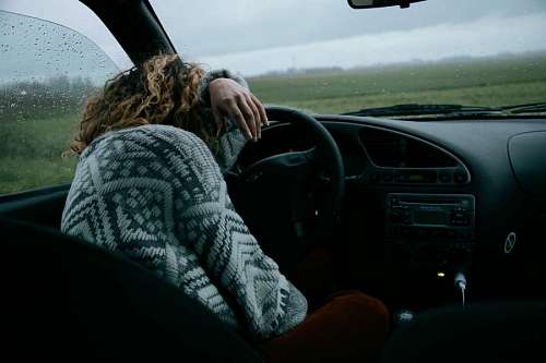 despair Sad woman in her car on a rainy day
