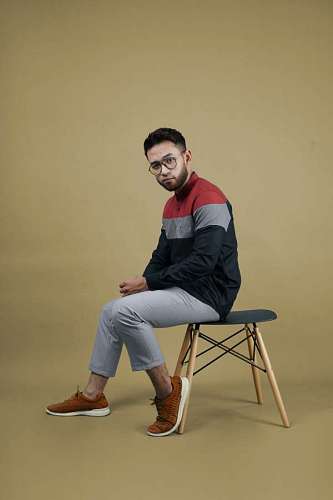 Young man with glasses looking at camera and posing in studio