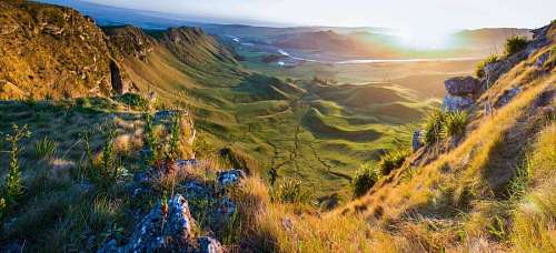 Mountain valley at sunset with sun reflections
