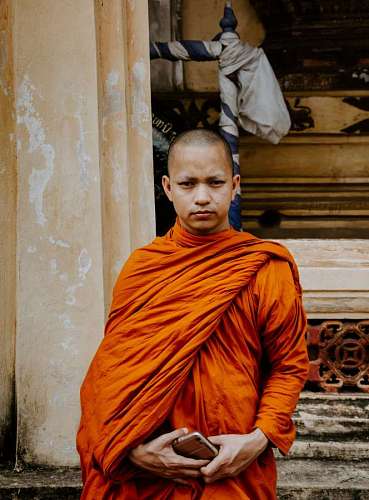 close-up of a Buddhist monk in front of a house