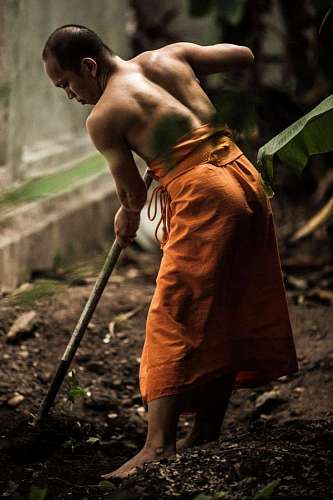 buddhist close-up of a monk digging a well