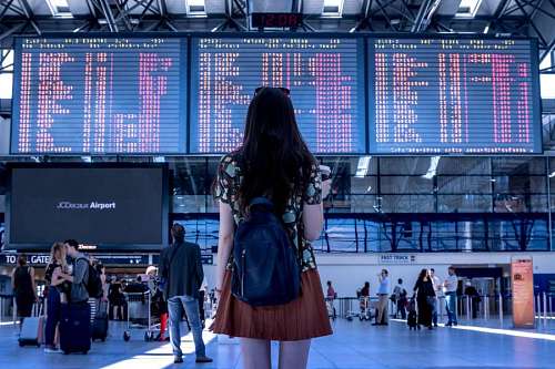 trip Woman looking at flight screen at airport