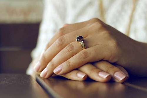 folded Woman's hands with engagement ring
