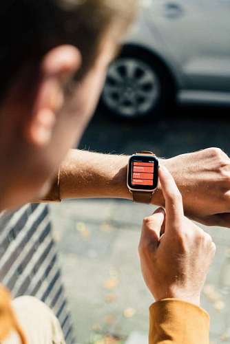 close-up of a man looking at his watch in the street