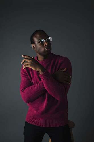 Man with glasses and re sweater posing