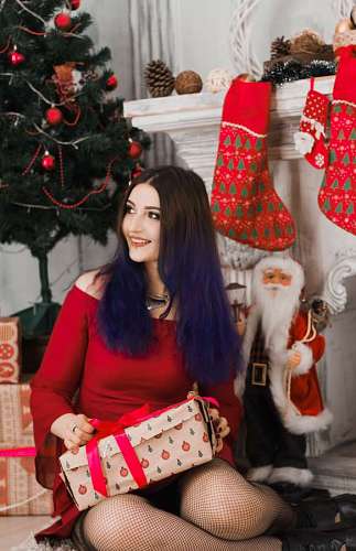 christmastime Young woman opening presents at Christmas in front of the tree