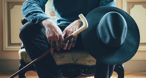 cane Stylish man with tattooed hands