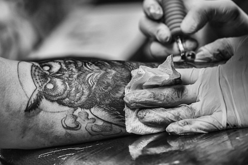 Artist tattooing an owl