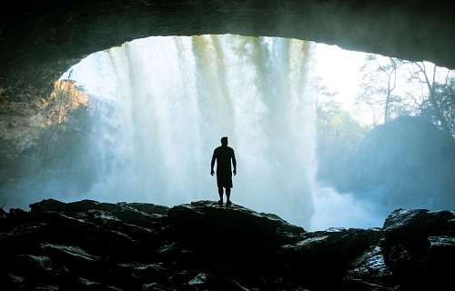wide-angle Man exploring a waterfall in the forest