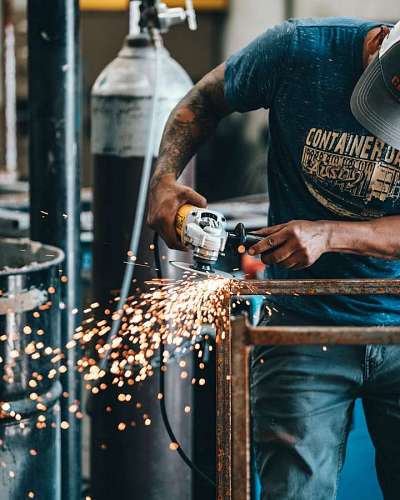craftsman cutting metal bar with a grinder