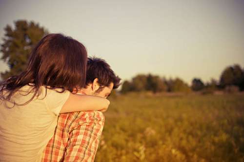 looking-over-shoulder Man carrying his girlfriend on his shoulders