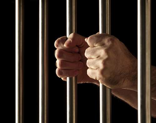 diego Man's hands taking prison bars