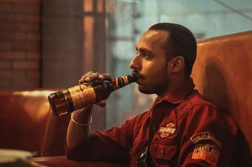 close-up of a man drinking beer alone while sitting