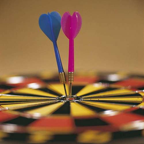 aim close-up of two darts in the center of a target