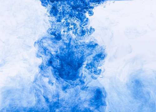 Background with texture of blue ink in transparent liquid