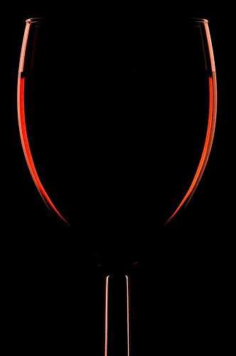 edges Silhouette of a glass of red wine on a black background