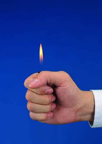 close-up of a hand with a lighter and a blue background