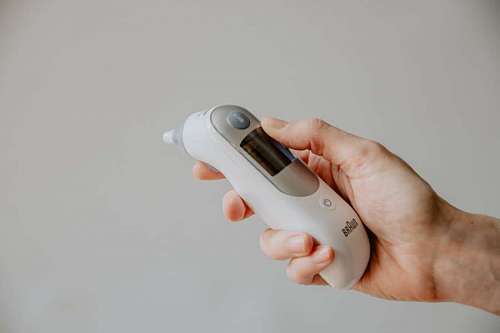  Man's Hand Holding an Electronic Thermometer