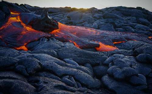 change closeup of volcanic lava with sunset in the background