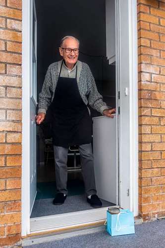elderly man receiving a gift during social distancing
