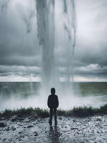 bad Young man in front of a waterfall