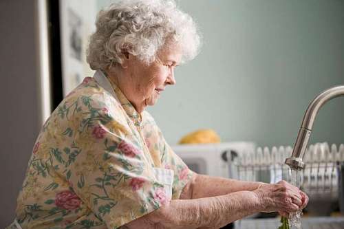 aging-process grandmother washing vegetables before cooking
