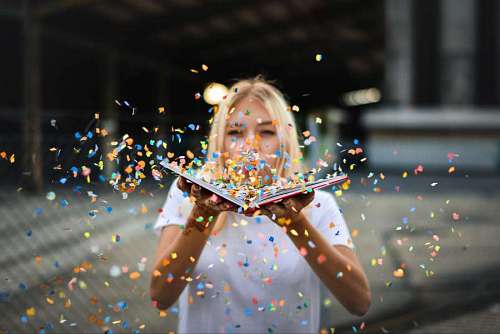 ceremonial Woman with open book blowing colored papers to celebrate