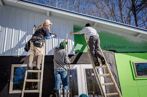 bricklayers painting a green house