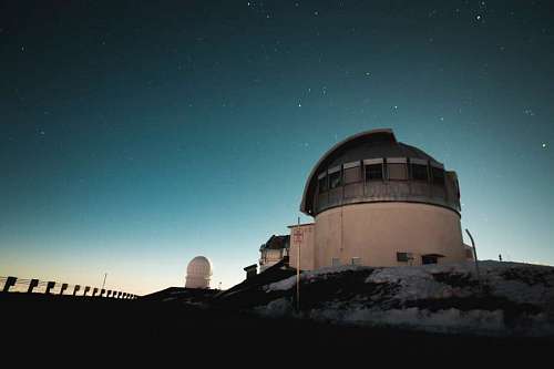 Astronomical observatory with starry sky in the background
