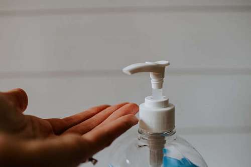 dispenser woman placing alcohol on her hand