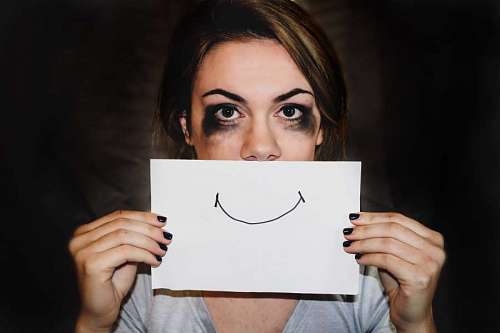 Sad woman, concept with drawing smile on a paper