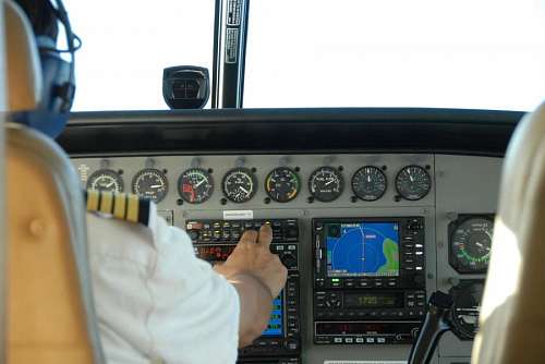 Airplane pilot calibrating navigation instruments in the flight deck
