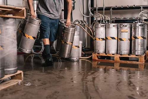 man lifting carafes on a wet floor