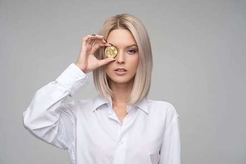 coin Blonde woman holding bitcoin coin, cryptocurrency concept