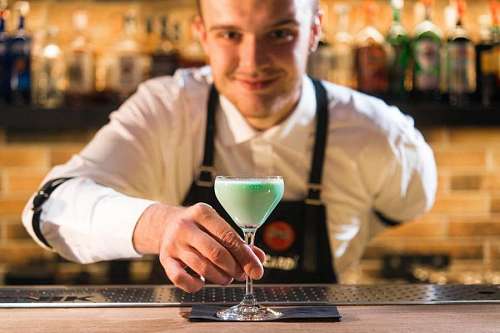 elaborate Bartender preparing a cocktail on a bar counter