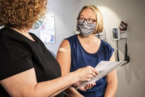 looking-over-shoulder Applying vaccine against covid 19