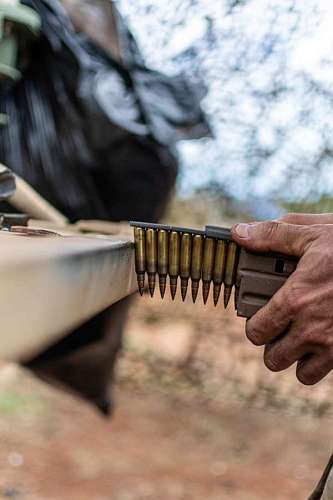 ash Military loading bullets into a machine gun