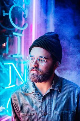 Young man with beard and glasses looking side