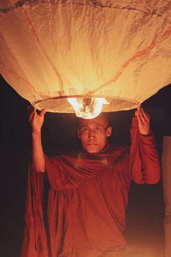 Buddhist Monk Holding a Globe at Night