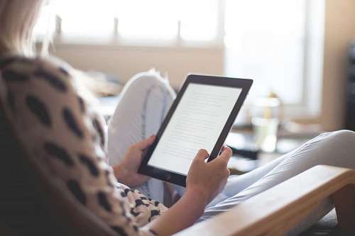 adolescence Young woman sitting reading an ebook on a tablet