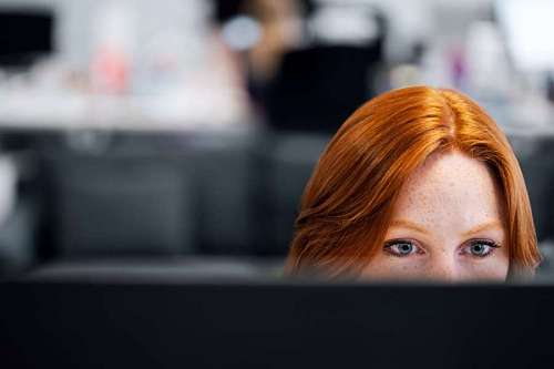 Working redhead woman at her desk
