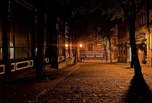 Cobbled street at night with street lamps, old city