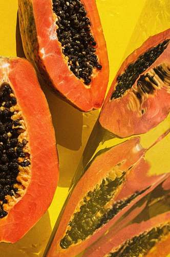 Papayas cut in half on yellow background