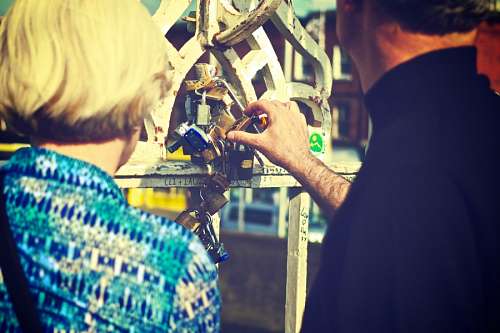 Bride and groom closing a lock on the bridge of lovers