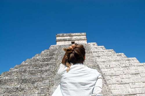 god Woman from behind looking at the great Mayan pyramid of Chichen Itza
