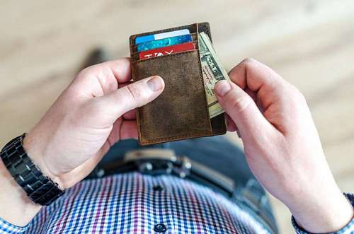 paying-in-store Man taking money out of his wallet to buy in business